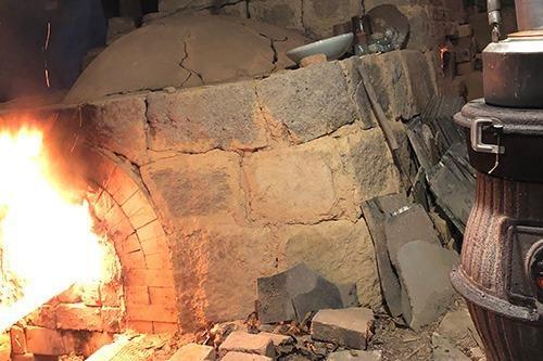 写真：割竹式登り窯と、窯の入り口から立ち上る炎の写真
