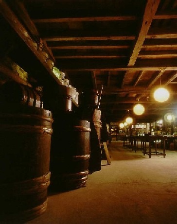 大きな樽が置かれた酒蔵の中の写真