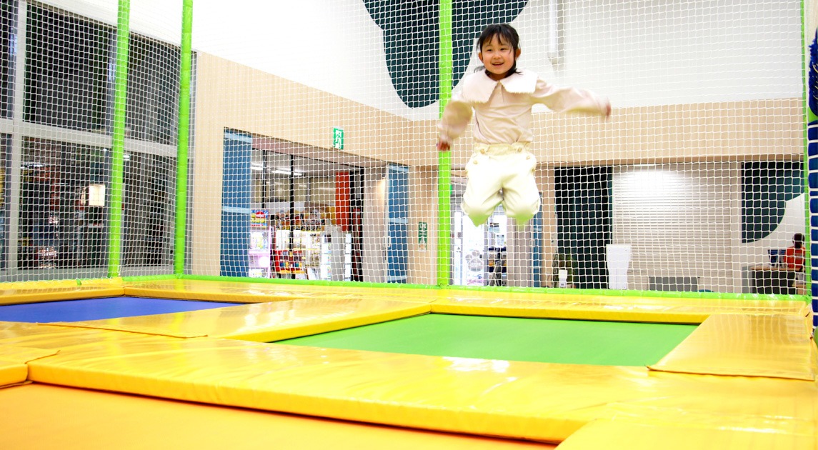 写真：トランポリンで跳んでいる子供