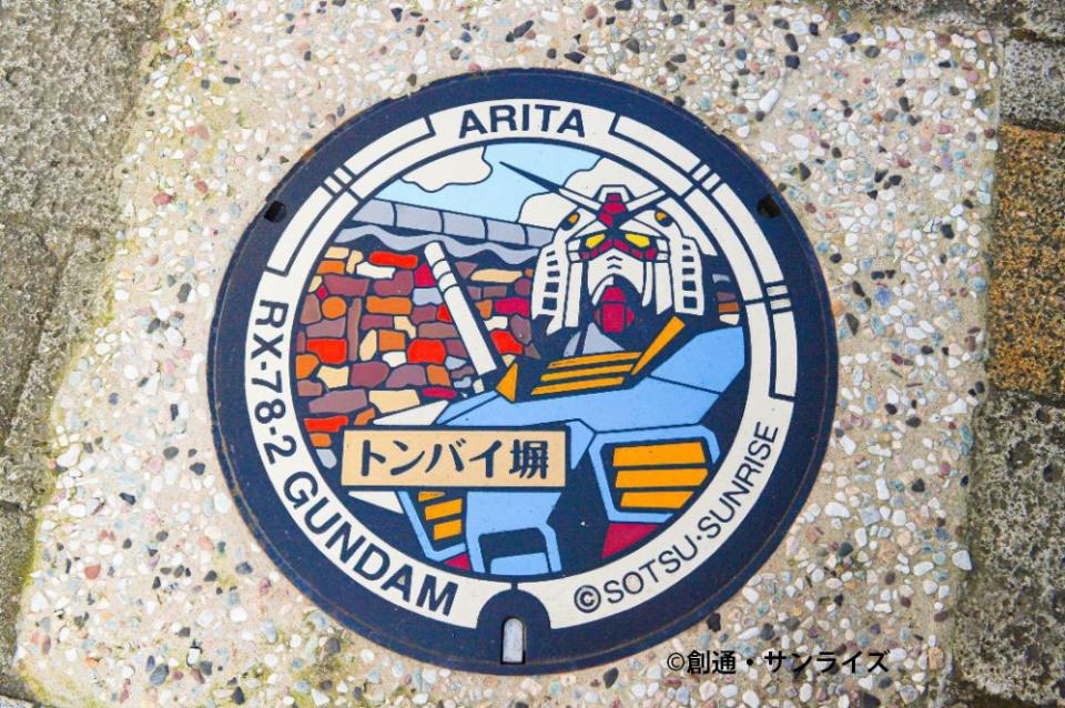 写真：ガンダムの図柄入りマンホール。ARITA、トンバイ塀の文字入り