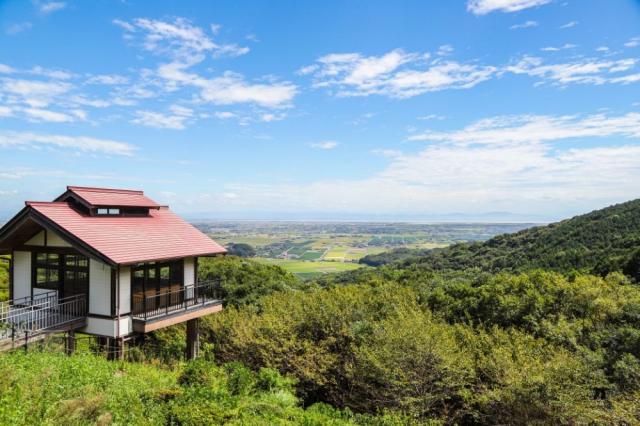 写真：山腹からの風景。画面左に歌垣公園内の展望所があり、中央遠景に佐賀平野を見おろす