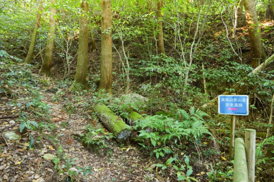 写真：「鷹取山登山道安全通路」の看板が出ている山道