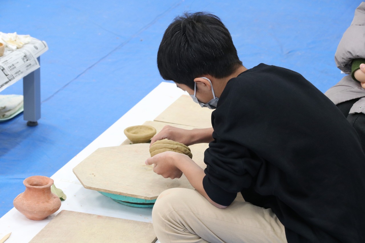 写真：土器をつくる少年