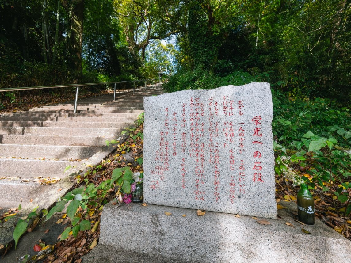 写真：石段とその横に建てられた古賀稔彦さんを称える石碑