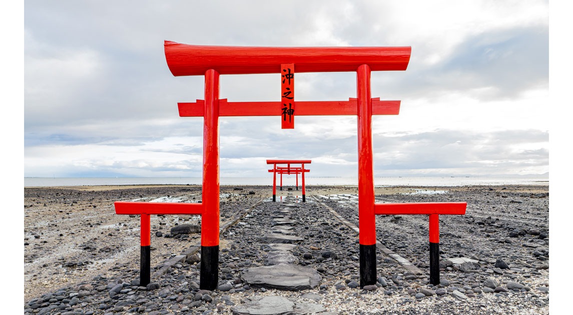 写真：潮が引いて現れた地面に鳥居が立っている風景