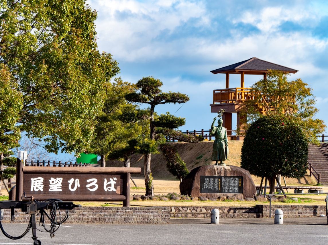 写真：道の駅にある展望ひろば。奥に丸太組みの展望台、手前に「展望ひろば」の看板がある