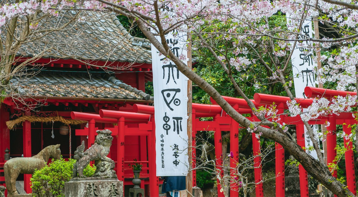 写真：朱塗りの鳥居と社がある風景