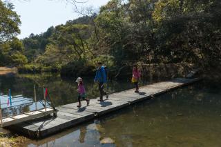 写真：山中の川の上の橋を渡る家族