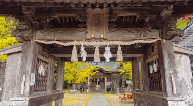 写真：「綾部神社」の扁額がかかった楼門から本殿を覗く様子