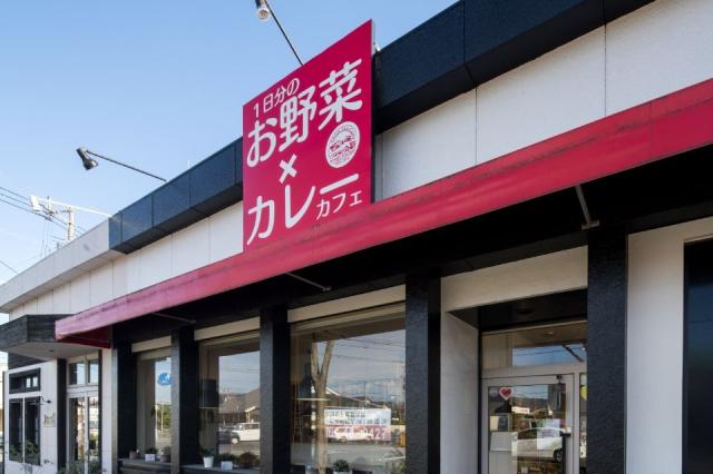 赤い看板と白い壁の店舗外観画像