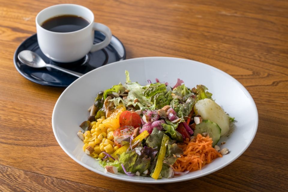 白い器に野菜サラダとコーヒーが添えられた画像